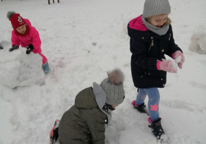 dziewczynki lepią kule śniegowe